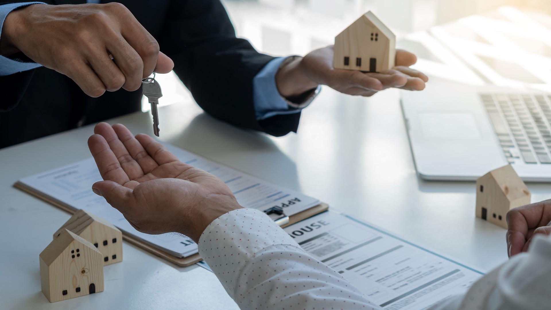 L’agent immobilier détient des clés de maison pour des clients après contrat dans le bureau, concept de l’achat à la maison ou du loyer avec l’assurance.